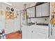 A laundry room with a washer and dryer set, utility sink, and overhead storage at 2885 Horseshoe Dr, Las Vegas, NV 89120