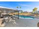 A covered patio overlooks a pool, complemented by palm trees, outdoor seating, and lush landscaping for relaxation at 2885 Horseshoe Dr, Las Vegas, NV 89120