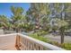 Private balcony with white railing overlooking street with mature landscaping and views of mature trees at 3111 Lido Isle Ct, Las Vegas, NV 89117