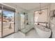 Modern bathroom featuring a glass shower and soaking tub with an exterior view at 3111 Lido Isle Ct, Las Vegas, NV 89117