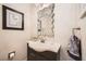 Stylish powder room with a uniquely designed mirror, modern sink, and neutral color scheme at 3111 Lido Isle Ct, Las Vegas, NV 89117