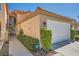 Charming townhome with two-car garage, manicured green bushes, and sidewalk at 3111 Lido Isle Ct, Las Vegas, NV 89117