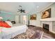 Beautiful primary bedroom with hardwood floors, fireplace, light blue walls, and a large oriental rug at 3111 Lido Isle Ct, Las Vegas, NV 89117