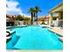 Large swimming pool surrounded by lounge chairs and palm trees within a gated community on a sunny day at 3111 Lido Isle Ct, Las Vegas, NV 89117
