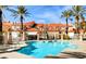 Community pool surrounded by palm trees and well-maintained Mediterranean-style townhomes under a bright sky at 3111 Lido Isle Ct, Las Vegas, NV 89117