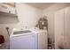 Laundry room featuring a white washer and dryer set along with a gray water heater at 3151 Soaring Gulls Dr # 1181, Las Vegas, NV 89128