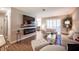 Open-plan living room has hardwood floors, a TV, electric fireplace, and neutral seating near a dining area at 3151 Soaring Gulls Dr # 1181, Las Vegas, NV 89128