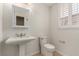 Bright bathroom with a pedestal sink, toilet, and window with white shutters at 3246 Brookfield Dr, Las Vegas, NV 89120
