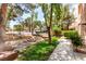 Charming landscaped front yard with mature trees, rock detail, and well-manicured lawn at 3246 Brookfield Dr, Las Vegas, NV 89120