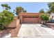 Two-car garage featuring an extended driveway and desert landscaping at 3246 Brookfield Dr, Las Vegas, NV 89120