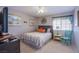 This is a cozy bedroom featuring a bed with colorful linens, a large clock, and cheerful decor at 3249 Dayflower St # C, Las Vegas, NV 89121