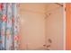 Bathroom with tub and shower featuring a peach-colored tile surround and colorful shower curtain at 3249 Dayflower St # C, Las Vegas, NV 89121