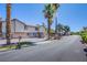 Exterior street view of the All Heatherstone community with well-maintained landscaping and palm trees at 3249 Dayflower St # C, Las Vegas, NV 89121