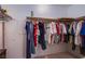 Walk-in closet with clothing hung on rods and shelving for storage, featuring a carpeted floor at 3249 Dayflower St # C, Las Vegas, NV 89121