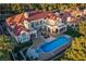 Stunning aerial view of a luxurious home with a red tile roof, manicured lawn, and a beautiful pool area at 35 Ventana Canyon Dr, Las Vegas, NV 89113