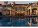 Luxurious backyard featuring a stunning pool reflecting the home's elegant architecture and windows at sunset at 35 Ventana Canyon Dr, Las Vegas, NV 89113