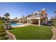 Expansive backyard with a refreshing pool, lush lawn, and a charming patio area, perfect for outdoor activities at 35 Ventana Canyon Dr, Las Vegas, NV 89113