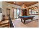 This game room offers a vaulted wood ceiling, balcony access, and a classic pool table ready for play at 35 Ventana Canyon Dr, Las Vegas, NV 89113