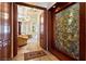 Elegant hallway with stone floors, rich wood trim, and stunning art installation, leading to a spacious living area at 35 Ventana Canyon Dr, Las Vegas, NV 89113