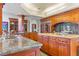 Well-lit kitchen with granite countertops, wood cabinetry, and a large island at 35 Ventana Canyon Dr, Las Vegas, NV 89113