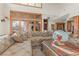 Open living room with stone floors, large sectional sofa, and abundant natural light at 35 Ventana Canyon Dr, Las Vegas, NV 89113