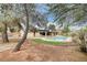 Large in-ground swimming pool surrounded by trees and a grass yard at 3575 W Robindale Rd, Las Vegas, NV 89139