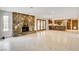 Bright, open living room with a stone fireplace, tile floors, and a view of the kitchen at 3575 W Robindale Rd, Las Vegas, NV 89139