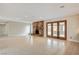Bright, open living room with a stone fireplace, tile floors, and glass paneled doors at 3575 W Robindale Rd, Las Vegas, NV 89139