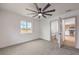 Bright bedroom with gray carpet, modern ceiling fan, and a doorway view to the kitchen at 40 Laswell St, Henderson, NV 89015