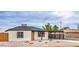 Single story home with a bright orange door and covered parking area with desert landscaping at 40 Laswell St, Henderson, NV 89015