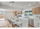 Bright kitchen features stainless steel appliances, white cabinets, quartz countertops, and an island with barstool seating at 40 Laswell St, Henderson, NV 89015
