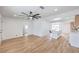 Open-concept living space features wood-look flooring, a modern fan, and seamless flow into the updated kitchen at 40 Laswell St, Henderson, NV 89015