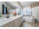 Bathroom featuring a double vanity and tiled shower-tub combination with a window at 4209 Glass Lantern Dr, North Las Vegas, NV 89032