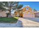 Charming two-story home featuring a well-manicured lawn, mature tree, and a two-car garage, creating a welcoming curb appeal at 4209 Glass Lantern Dr, North Las Vegas, NV 89032