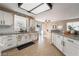 Bright kitchen with white cabinets, granite countertops, tile floors, modern fixtures, and stainless steel sink at 4209 Glass Lantern Dr, North Las Vegas, NV 89032