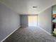 Bright, empty living room with plush carpeting and sliding glass doors for ample natural light at 4400 Sandy River Dr # 4, Las Vegas, NV 89103