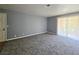 Empty living room features neutral tones, sliding glass doors and a carpeted floor at 4400 Sandy River Dr # 4, Las Vegas, NV 89103