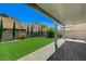 A beautifully landscaped backyard includes green artificial turf and a covered patio at 4503 Meteora Ledge Ave, North Las Vegas, NV 89084