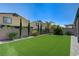 A beautifully landscaped backyard includes green artificial turf and a decorative brick wall at 4503 Meteora Ledge Ave, North Las Vegas, NV 89084