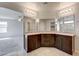 Bright bathroom featuring double vanity with granite counters and dark wood cabinets at 4503 Meteora Ledge Ave, North Las Vegas, NV 89084