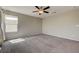 Spacious bedroom with a large window, ceiling fan and neutral-colored carpet at 4503 Meteora Ledge Ave, North Las Vegas, NV 89084