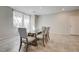 Bright dining area with tile flooring, neutral walls, and a modern glass top dining table at 4503 Meteora Ledge Ave, North Las Vegas, NV 89084