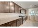 Modern kitchen featuring stainless steel appliances, granite countertops, and dark wood cabinets at 4503 Meteora Ledge Ave, North Las Vegas, NV 89084