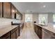Modern kitchen featuring stainless steel appliances, granite countertops, and dark wood cabinets at 4503 Meteora Ledge Ave, North Las Vegas, NV 89084