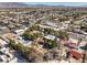 Expansive aerial view of the property surrounded by mature trees, other homes, and the distant mountains at 5715 Gilbert Ln, Las Vegas, NV 89130