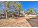 Backyard with large trees, grass, and weeds at 5715 Gilbert Ln, Las Vegas, NV 89130