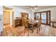 Traditional dining room with rustic tile flooring, wooden furniture, and a large window with a patio view at 5715 Gilbert Ln, Las Vegas, NV 89130