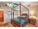 Bedroom featuring a four-poster bed, ceiling fan, and decorative lamps on matching nightstands at 5715 Gilbert Ln, Las Vegas, NV 89130