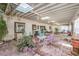 Spacious covered patio with skylights, multiple seating areas, and brick flooring at 5715 Gilbert Ln, Las Vegas, NV 89130