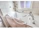 Close-up of a walk-in tub with jets, chrome fixtures, safety features and decorative tiling at 5715 Gilbert Ln, Las Vegas, NV 89130